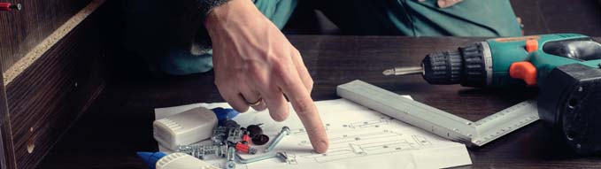 Frustrated man reading instruction and putting together self assembly furniture. DIY, new home and moving concept