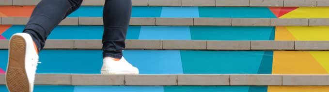 Lower part of teenage girl in casual shoe walking up outdoor colorful stair,teenage lifestyle successful concept