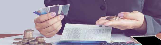 business woman hand calculating her monthly expenses during tax season with coins, calculator, credit card and account bank, idea for dept collection background