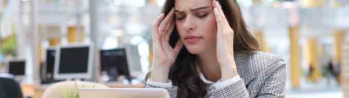 Frustrated business woman looking exhausted while sitting at her working place