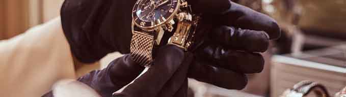 Close-up of the seller's hands in gloves shows the exclusive men's watch from the new collection in the luxury jewelry store