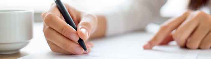 Hand of businesswoman writing on paper in office