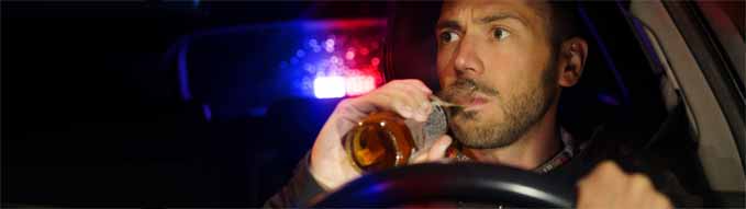 Police stopped car with drunk driver inside. Drunk man drinking alcohol while driving car. Driver under alcohol influence
