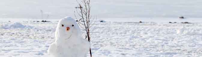 Smiling snowman stands on white snowdrift on the coast of frozen Baltic Sea