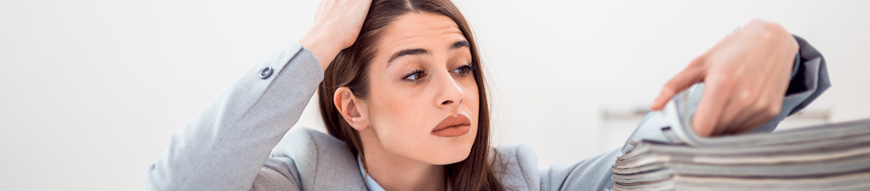 Exhausted office worker with pile of files.