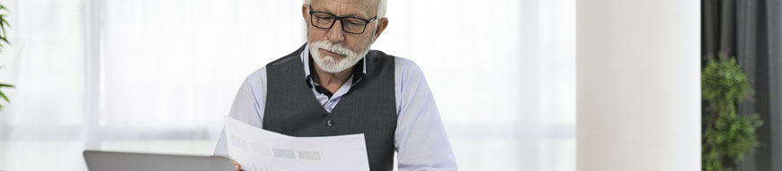 Smiling senior manager looking at business reports Concept of modern age business run by elderly man